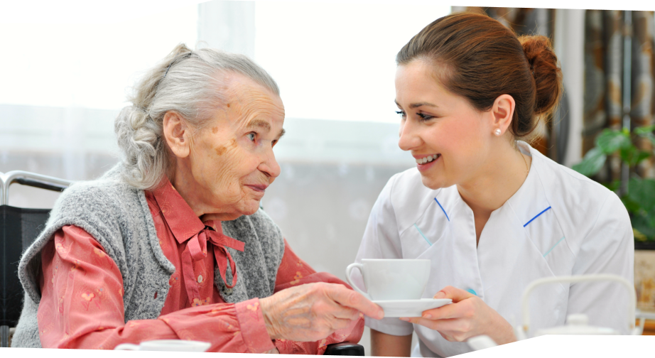 caregiver handling mug to her patient