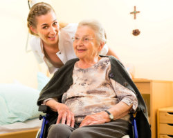 elder woman and caregiver smiling